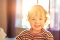 Smiling girl in the background of the sunset in a bedroom. Close-up. Young girl, beauty portrait. Sunny day. Cute baby indoor.