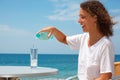 Smiling girl on beach pours water into glass Royalty Free Stock Photo