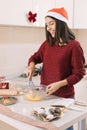 Smiling girl beating eggs in the kitchen