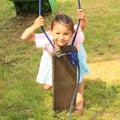 Smiling girl behind a broken swing