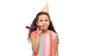 smiling girl in birthday party hat with blower Royalty Free Stock Photo