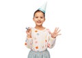 smiling girl in birthday party hat with blower Royalty Free Stock Photo