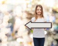 Smiling girl with blank arrow pointing left Royalty Free Stock Photo