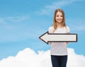 Smiling girl with blank arrow pointing left Royalty Free Stock Photo