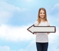 Smiling girl with blank arrow pointing left Royalty Free Stock Photo