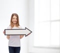 Smiling girl with blank arrow pointing right Royalty Free Stock Photo