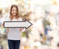 Smiling girl with blank arrow pointing right Royalty Free Stock Photo