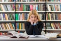 Smiling girl with blonde hair sitting at a desk in the lib