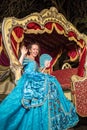 The smiling girl in blue old-fashioned dress sits Royalty Free Stock Photo