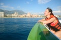 A smiling girl in a boat in the lifejacket