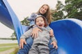 Smiling girl and boy having fun on children`s slide