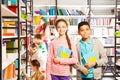 Smiling girl and boy in library with books Royalty Free Stock Photo