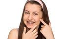Smiling girl with braces squeezing pimple isolated