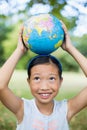 Smiling girl carrying a globe on her head Royalty Free Stock Photo