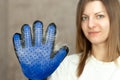 Smiling girl with cat shedding, bathing, grooming, deshedding glove.The glove with cats hair on it. equipment for caring domestic Royalty Free Stock Photo