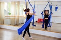Smiling girl climbing acrobatic gymnastic girl exercising on fabric ropeon rope