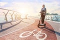 Young woman with colored dreadlocks  riding electric scooter Royalty Free Stock Photo