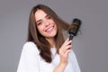 Smiling girl combing hair. Beautiful young woman holding comb straightened hair. Attractive smiling woman portrait with Royalty Free Stock Photo
