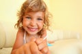 Smiling girl in cosy room, stretches hands forward