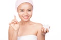 Smiling girl in a cream on her finger, holding a box of cosmetic cream looking at the camera Royalty Free Stock Photo