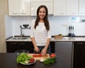 Smiling girl cuts tomato in salad