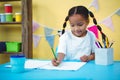 Smiling girl drawing in her colouring book Royalty Free Stock Photo