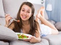 Smiling girl is eating salad because she being on vegetable diet Royalty Free Stock Photo