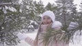 Smiling girl enjoying winter snowfall at snowy weather in forest slow motion Royalty Free Stock Photo