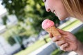 Smiling girl enjoys her strawberry ice cream during a summer day