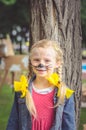 Smiling girl with face painting of mouse and long blond hair tail