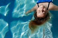 Smiling girl floating in the pool with negative space