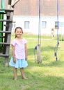 Smiling girl in front of broken swing