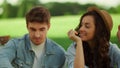 Smiling girl and guy speaking on lawn in park. Couple laughing on picnic Royalty Free Stock Photo