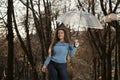 Smiling girl is having fun in autumn park. Student stands on alley with transparent umbrella in hands Royalty Free Stock Photo