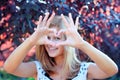 Smiling girl with heart sign