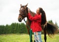 Smiling girl with her brown horse Royalty Free Stock Photo