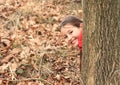 Smiling girl hiding behind tree Royalty Free Stock Photo