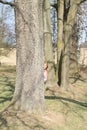 Smiling girl hiding behind tree Royalty Free Stock Photo