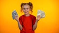 Smiling girl holding bunches of dollar cash and looking to camera, motivation Royalty Free Stock Photo