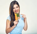 Smiling girl holding glass with carrot and pointing finger. Royalty Free Stock Photo