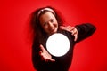 Smiling girl holding a glowing ball in her hands Red background Royalty Free Stock Photo