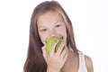 Young girl is biting a green apple. Royalty Free Stock Photo