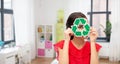 smiling girl holding green recycling sign