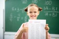 Smiling girl holding her answer sheet with excellent mark Royalty Free Stock Photo