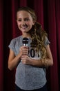 Girl holding microphone on stage Royalty Free Stock Photo