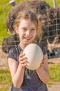 Smiling girl holding ostrich egg Royalty Free Stock Photo