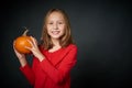 Smiling girl holding ripe pumpkin looking at camera Royalty Free Stock Photo