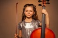 Smiling girl holding string to play violoncello Royalty Free Stock Photo