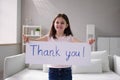 Smiling Girl Holding Thank You Sign Against White Royalty Free Stock Photo