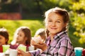 Smiling girl holds cupcake with her friends behind Royalty Free Stock Photo